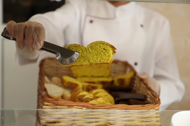 Photo of School canteen worker with basket of bread at serving line, closeup. Tasty food