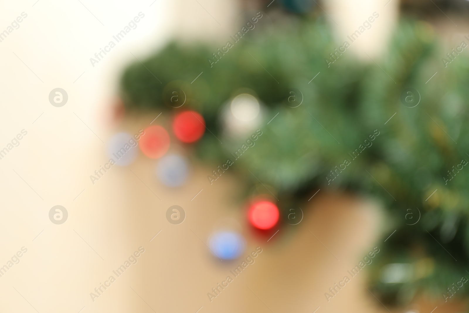 Blurred view of fir branches with festive decor on light background. Christmas time Photo of Blurred view of fir branches with festive decor on light background. Christmas time