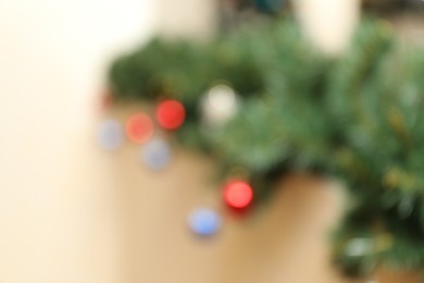 Photo of Blurred view of fir branches with festive decor on light background. Christmas time