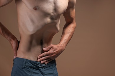 Photo of Man suffering from anorexia on beige background, closeup. Space for text