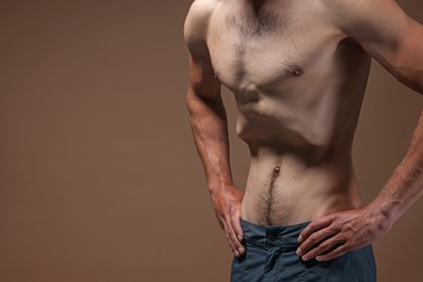 Photo of Man suffering from anorexia on beige background, closeup. Space for text