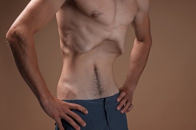 Photo of Man suffering from anorexia on beige background, closeup