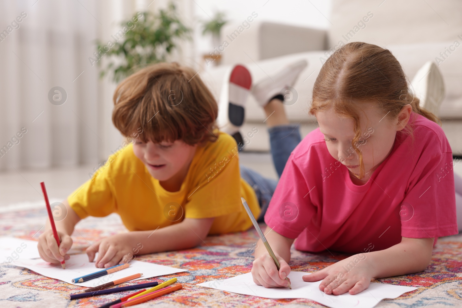 Cute kids learning to draw on floor at home Photo of Cute kids learning to draw on floor at home