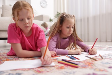 Photo of Cute kids learning to draw on floor at home