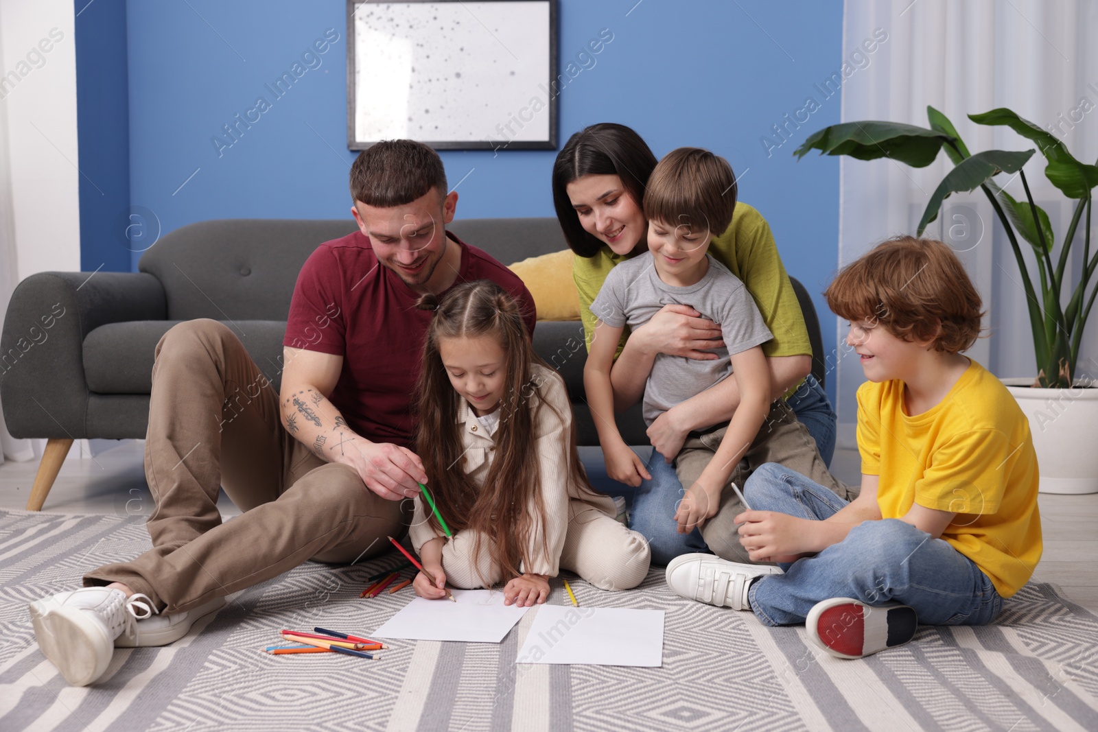 Parents teaching their kids to draw on floor at home Photo of Parents teaching their kids to draw on floor at home