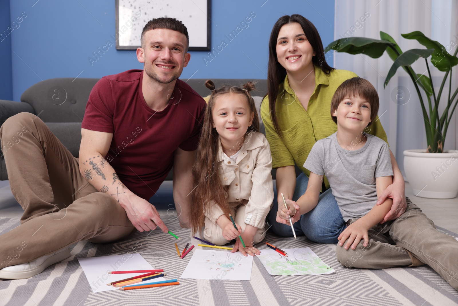 Parents teaching their kids to draw on floor at home Photo of Parents teaching their kids to draw on floor at home