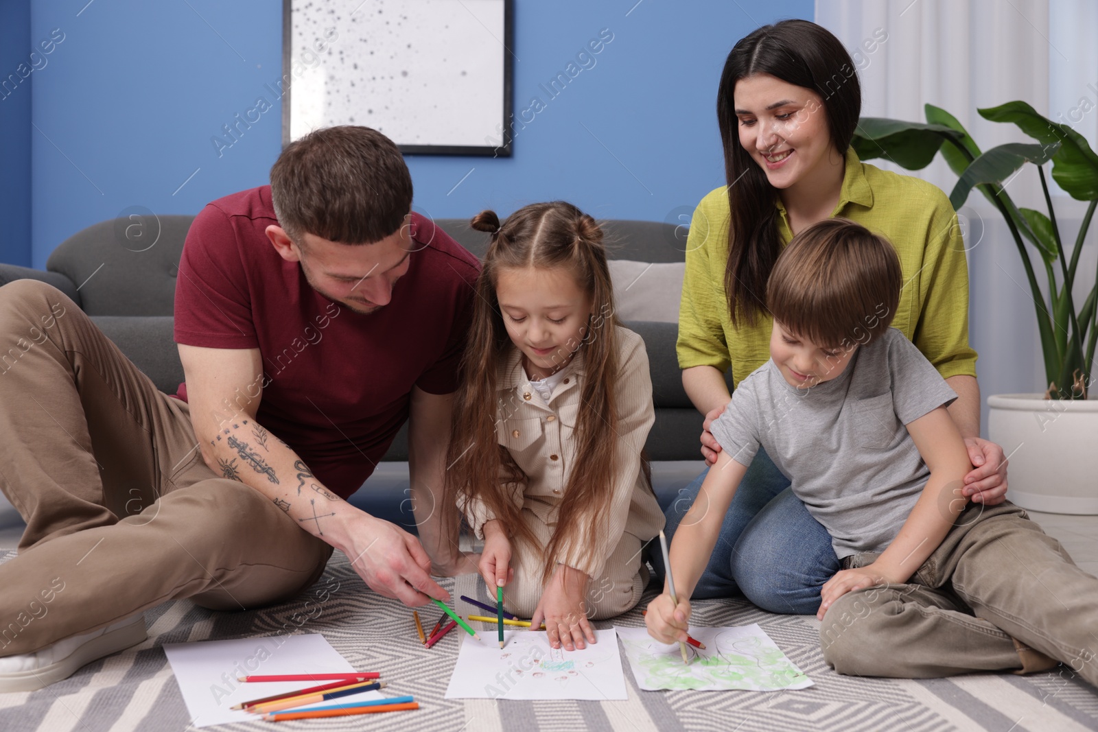 Parents teaching their kids to draw on floor at home Photo of Parents teaching their kids to draw on floor at home