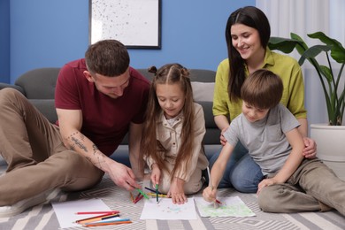 Photo of Parents teaching their kids to draw on floor at home