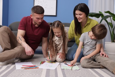 Photo of Parents teaching their kids to draw on floor at home