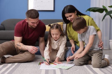 Photo of Parents teaching their kids to draw on floor at home