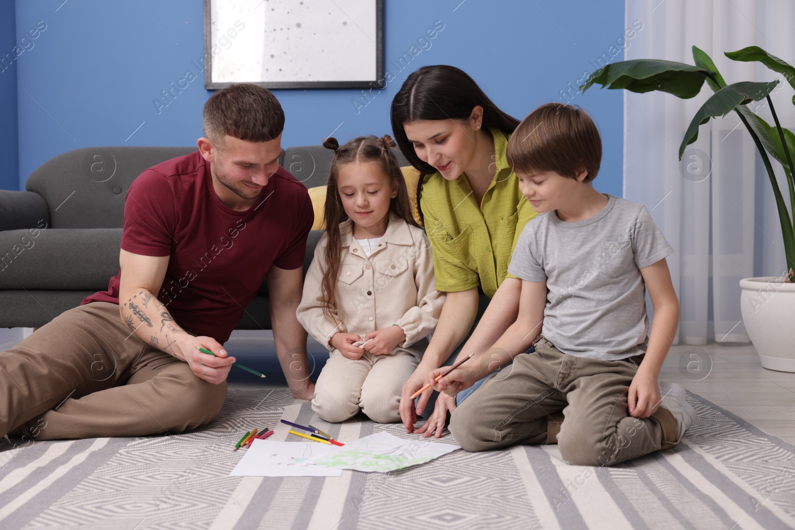 Parents teaching their kids to draw on floor at home Photo of Parents teaching their kids to draw on floor at home
