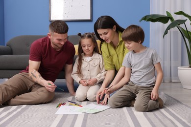 Photo of Parents teaching their kids to draw on floor at home
