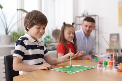Photo of Kids with teacher at painting lesson, selective focus. Learning to draw