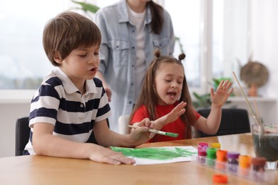 Photo of Kids with teacher at painting lesson, selective focus. Learning to draw