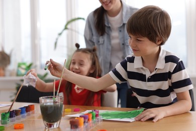 Photo of Kids with teacher at painting lesson, selective focus. Learning to draw