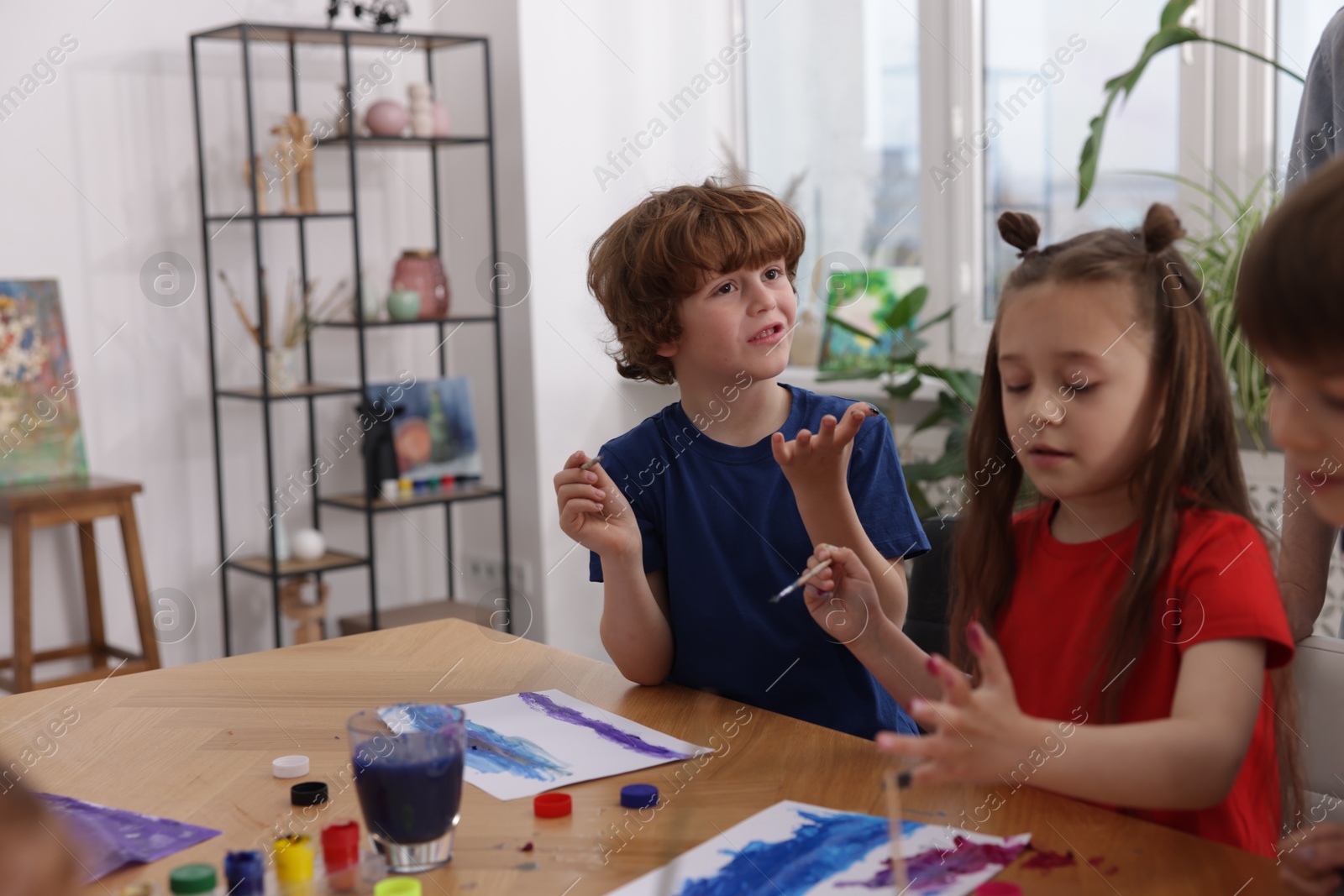 Kids painting at table indoors. Learning to draw Photo of Kids painting at table indoors. Learning to draw