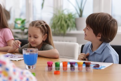 Photo of Kids painting at table indoors. Learning to draw