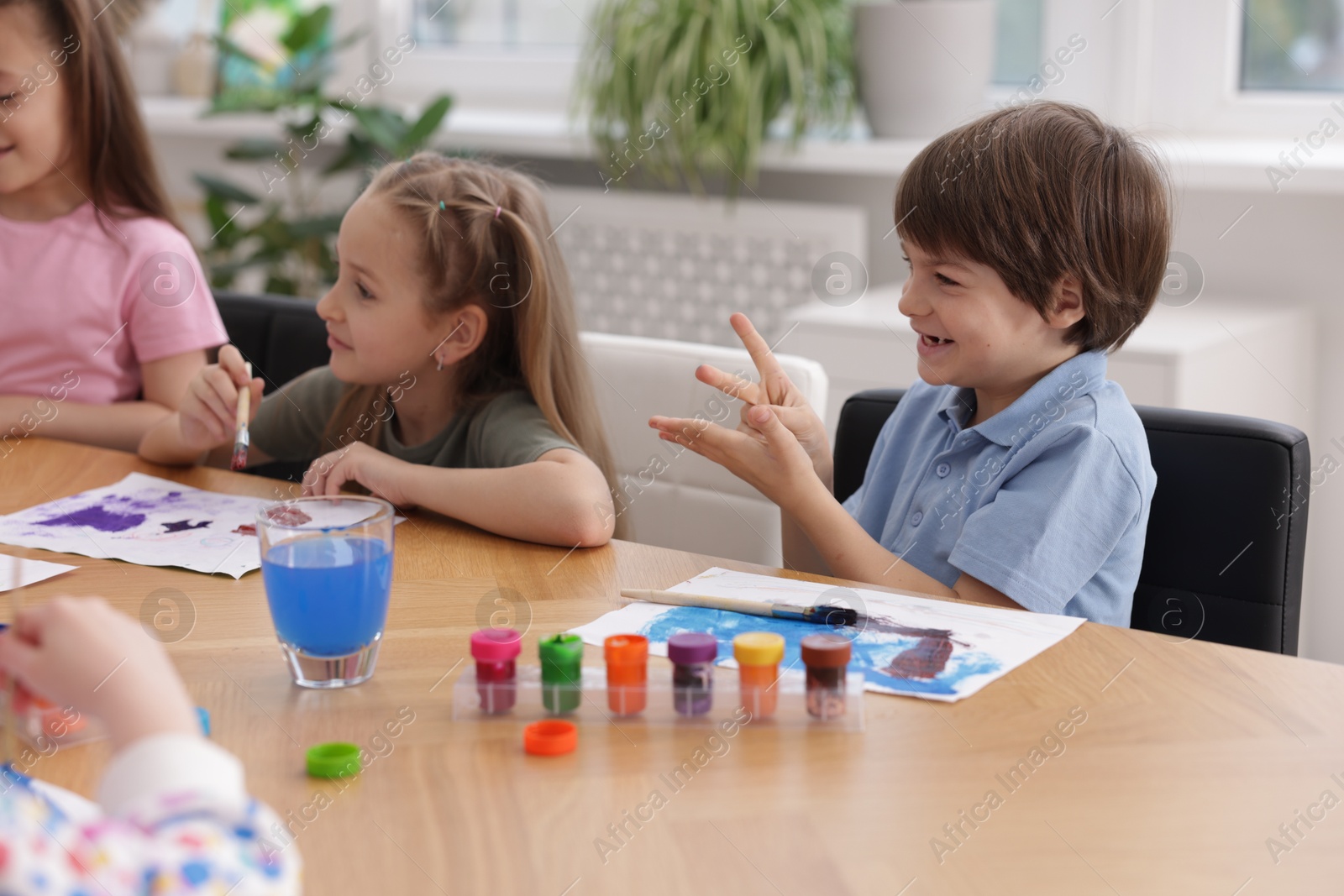 Kids painting at table indoors. Learning to draw Photo of Kids painting at table indoors. Learning to draw
