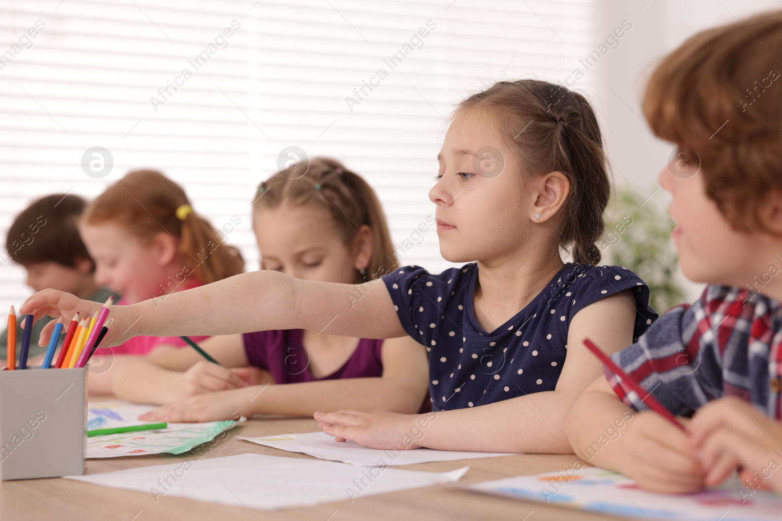 Kids painting at table indoors, selective focus. Learning to draw Photo of Kids painting at table indoors, selective focus. Learning to draw