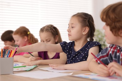 Photo of Kids painting at table indoors, selective focus. Learning to draw
