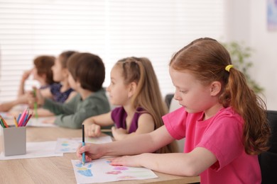 Photo of Kids painting at table indoors, selective focus. Learning to draw