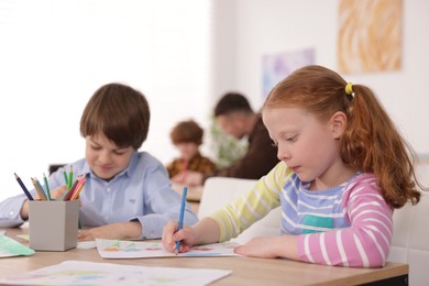 Photo of Kids with teacher at painting lesson indoors, selective focus. Learning to draw