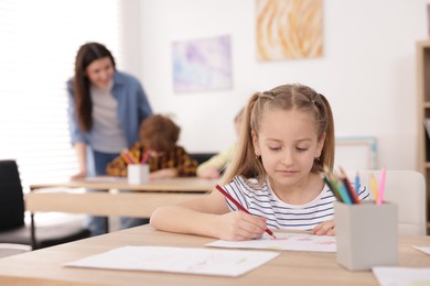 Photo of Kids with teacher at painting lesson indoors, selective focus. Learning to draw