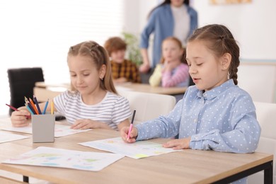 Photo of Kids with teacher at painting lesson indoors, selective focus. Learning to draw