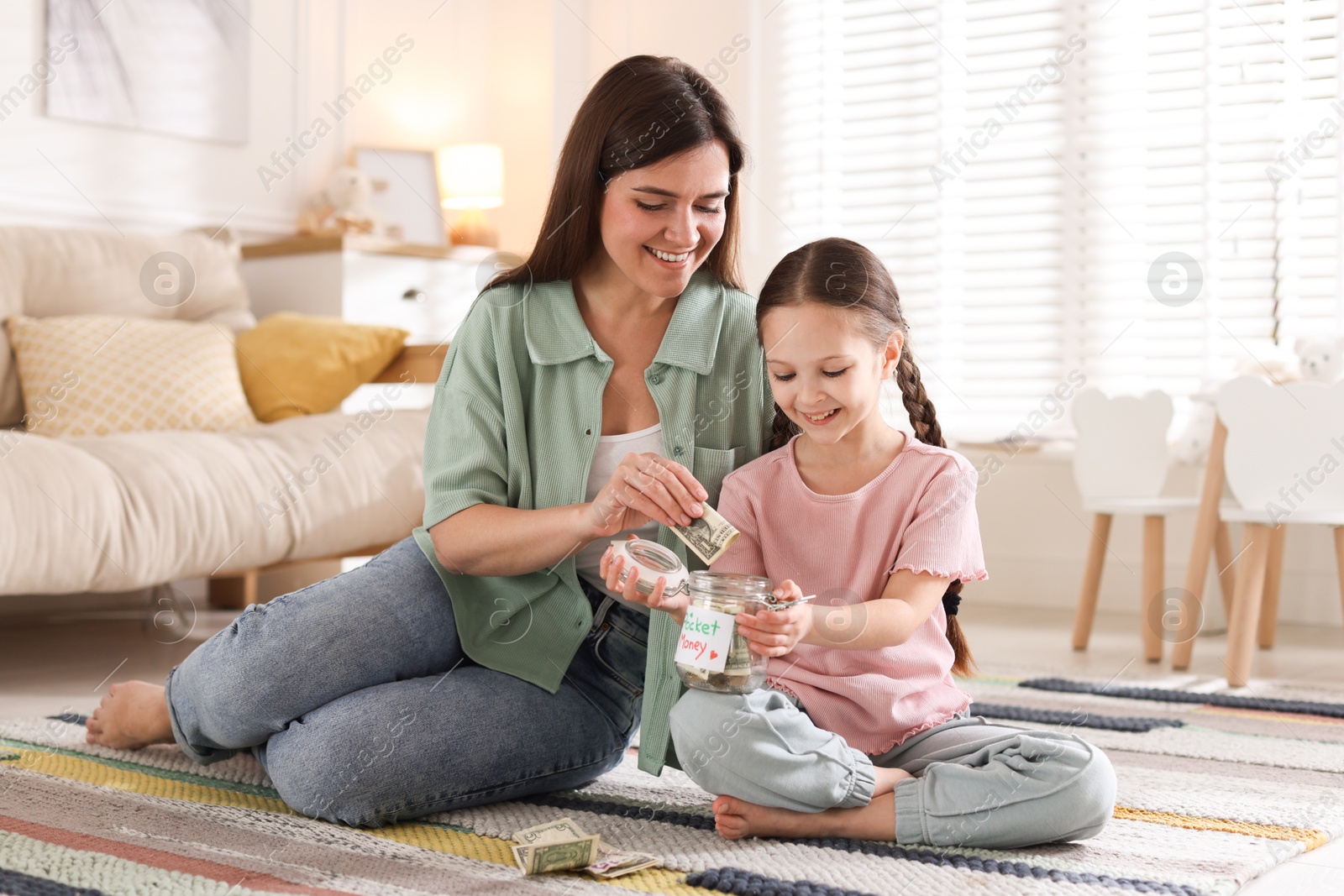 Mother giving pocket money to her daughter at home Photo of Mother giving pocket money to her daughter at home