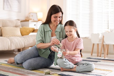 Photo of Mother giving pocket money to her daughter at home