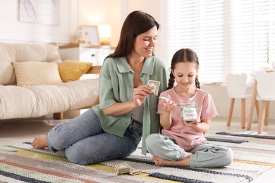 Photo of Mother giving pocket money to her daughter at home