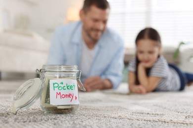 Photo of Jar with pocket money, father and daughter at home, selective focus