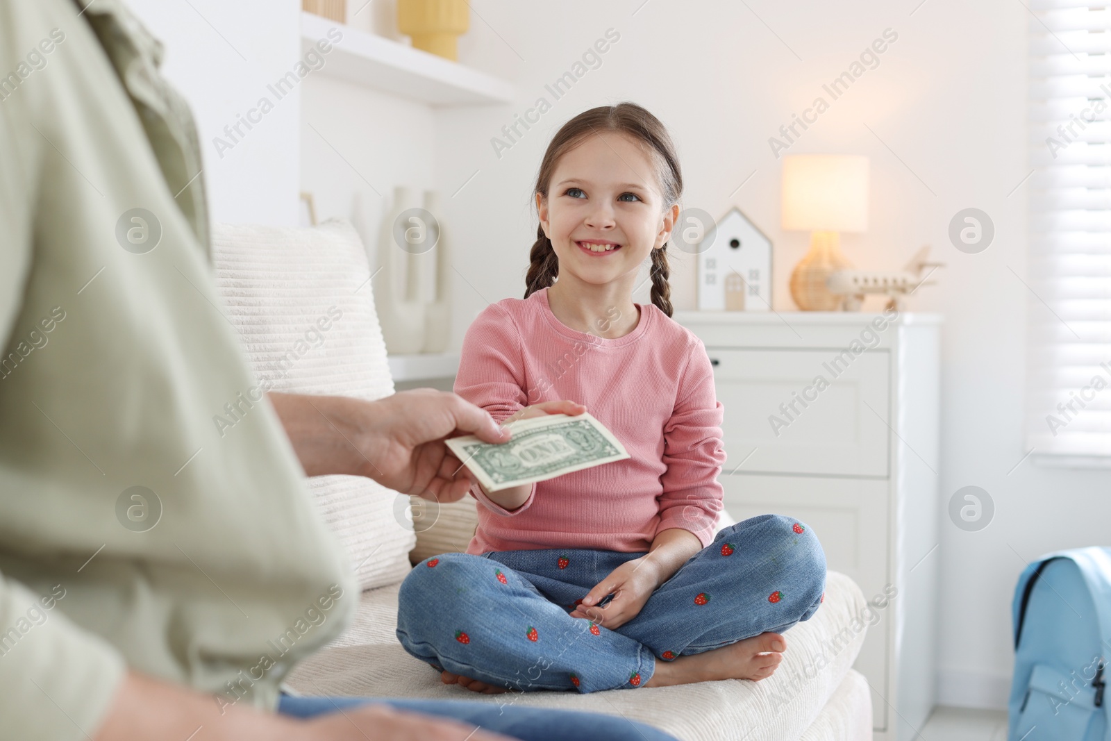 Father giving his daughter pocket money on sofa at home, closeup Photo of Father giving his daughter pocket money on sofa at home, closeup