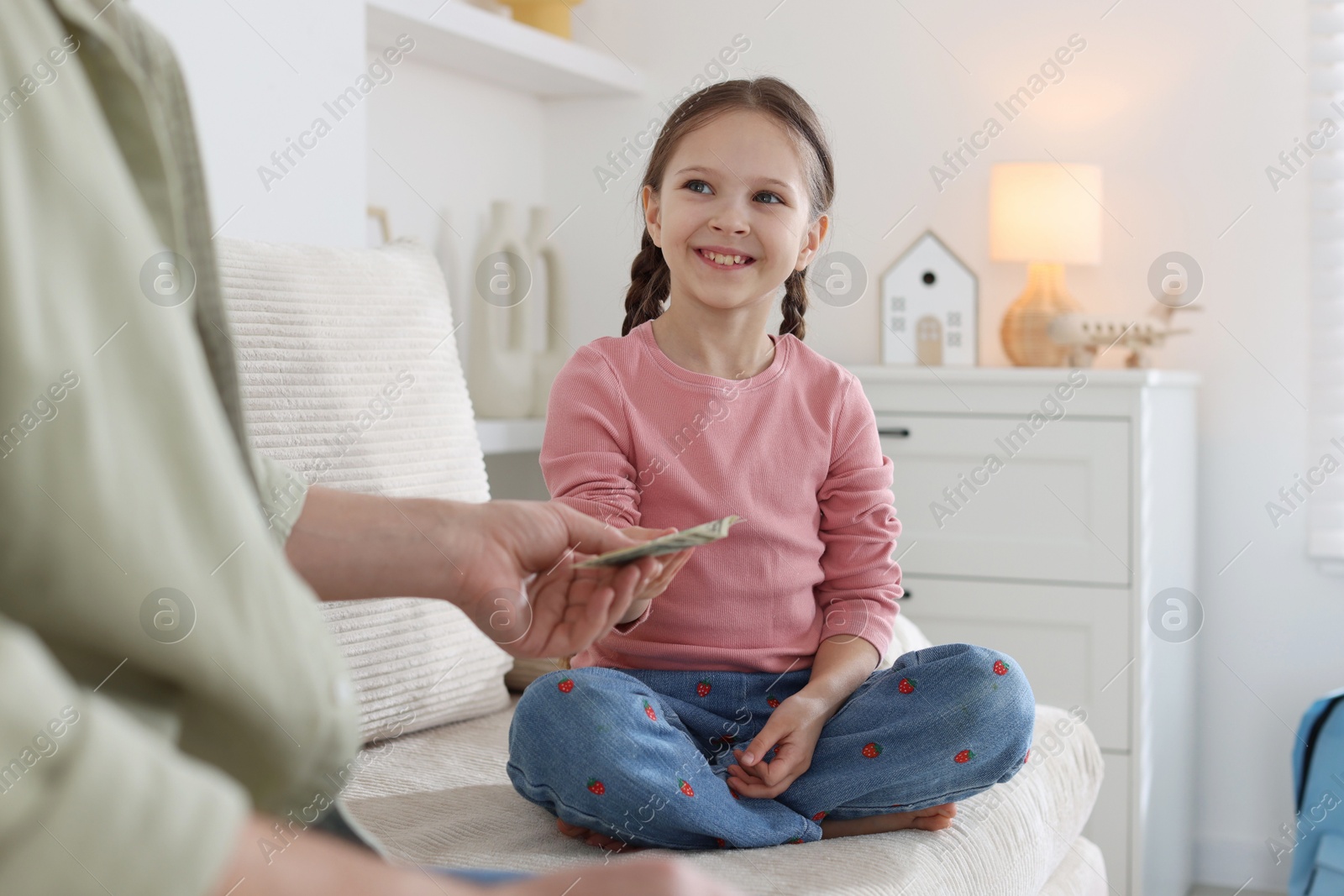 Father giving his daughter pocket money on sofa at home, closeup Photo of Father giving his daughter pocket money on sofa at home, closeup