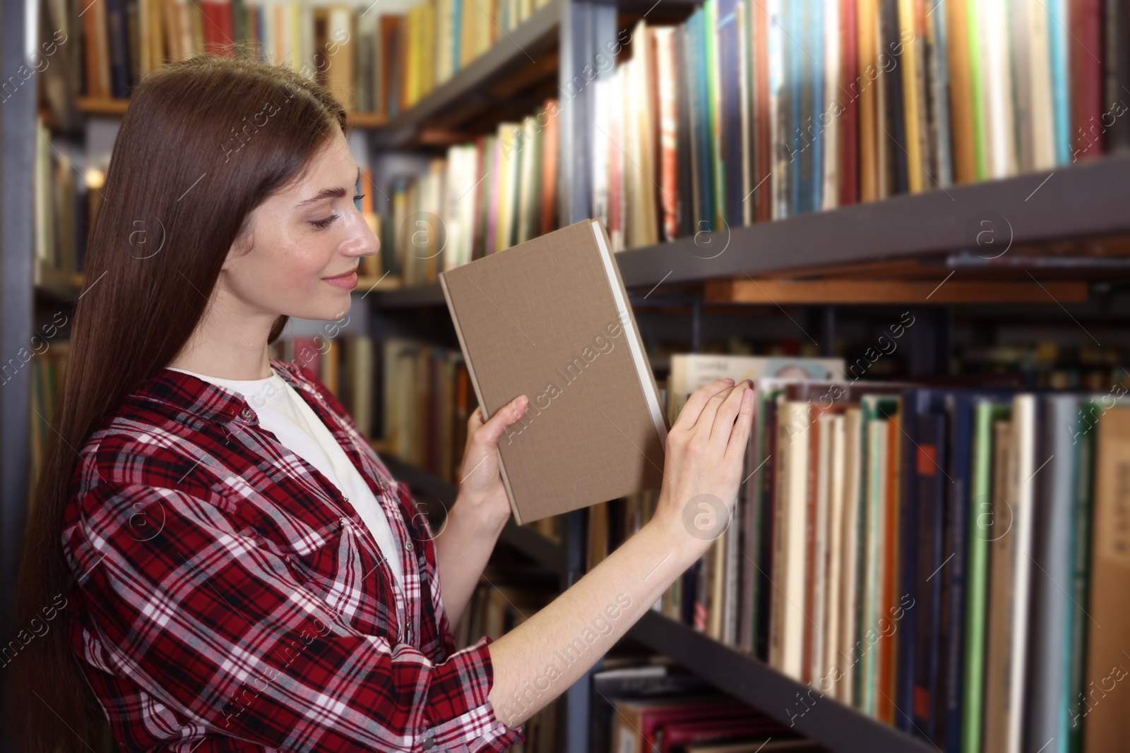 Woman taking book from shelf in public library Photo of Woman taking book from shelf in public library