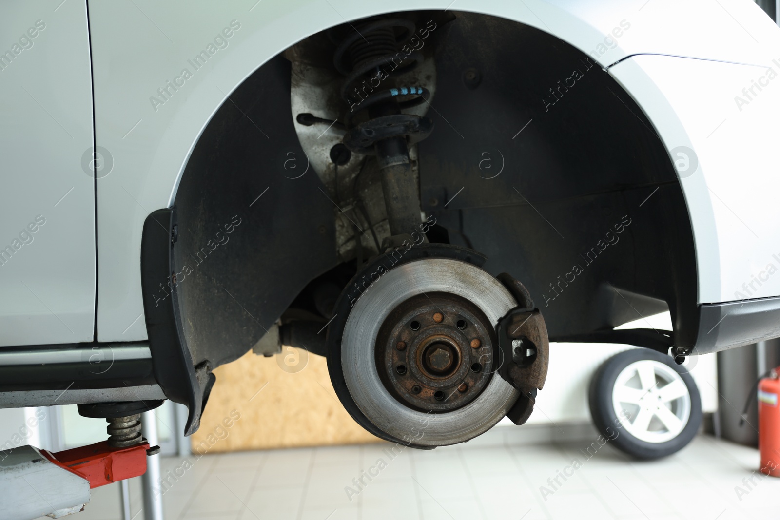 Photo of Lifted automobile during tire change at car service, closeup