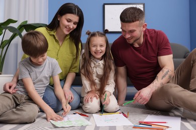 Photo of Parents teaching their kids to draw on floor at home