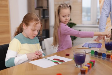 Photo of Kids with teacher at painting lesson. Learning to draw