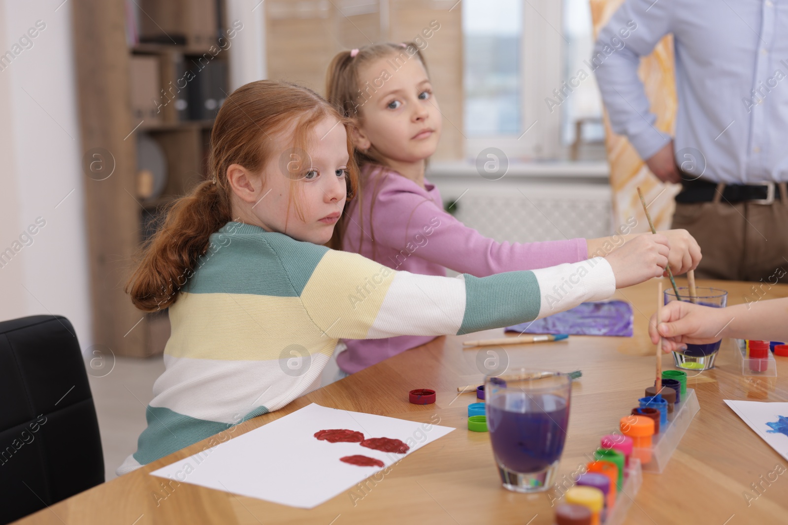 Kids with teacher at painting lesson. Learning to draw Photo of Kids with teacher at painting lesson. Learning to draw