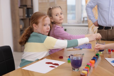 Photo of Kids with teacher at painting lesson. Learning to draw
