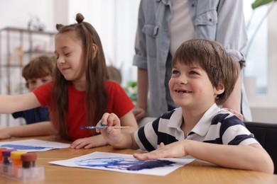 Photo of Kids with teacher at painting lesson. Learning to draw