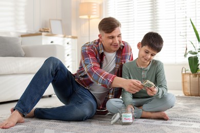 Photo of Father giving his son pocket money at home