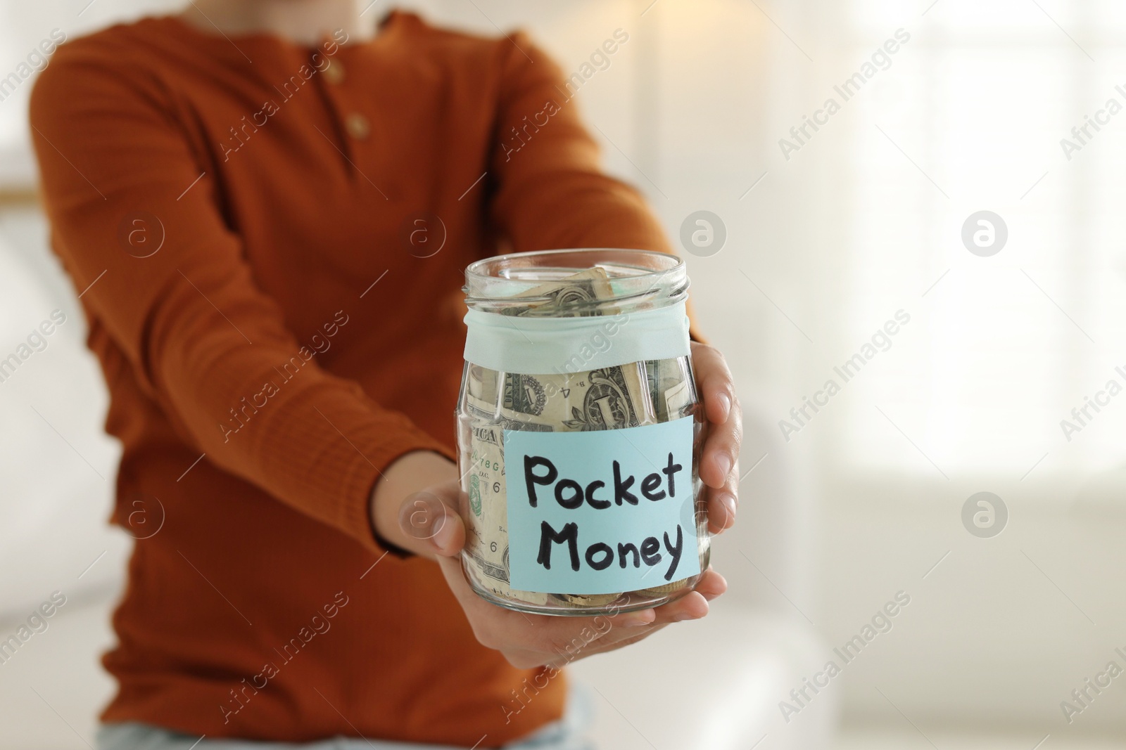 Boy with jar of pocket money at home, closeup. Space for text Photo of Boy with jar of pocket money at home, closeup. Space for text