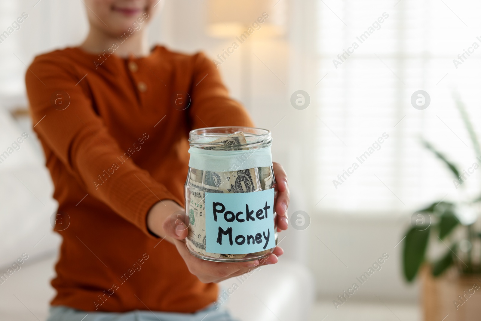 Boy with jar of pocket money at home, closeup. Space for text Photo of Boy with jar of pocket money at home, closeup. Space for text