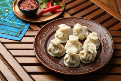Photo of Delicious khinkali served on wooden table, above view