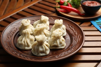 Photo of Delicious khinkali served on wooden table, closeup