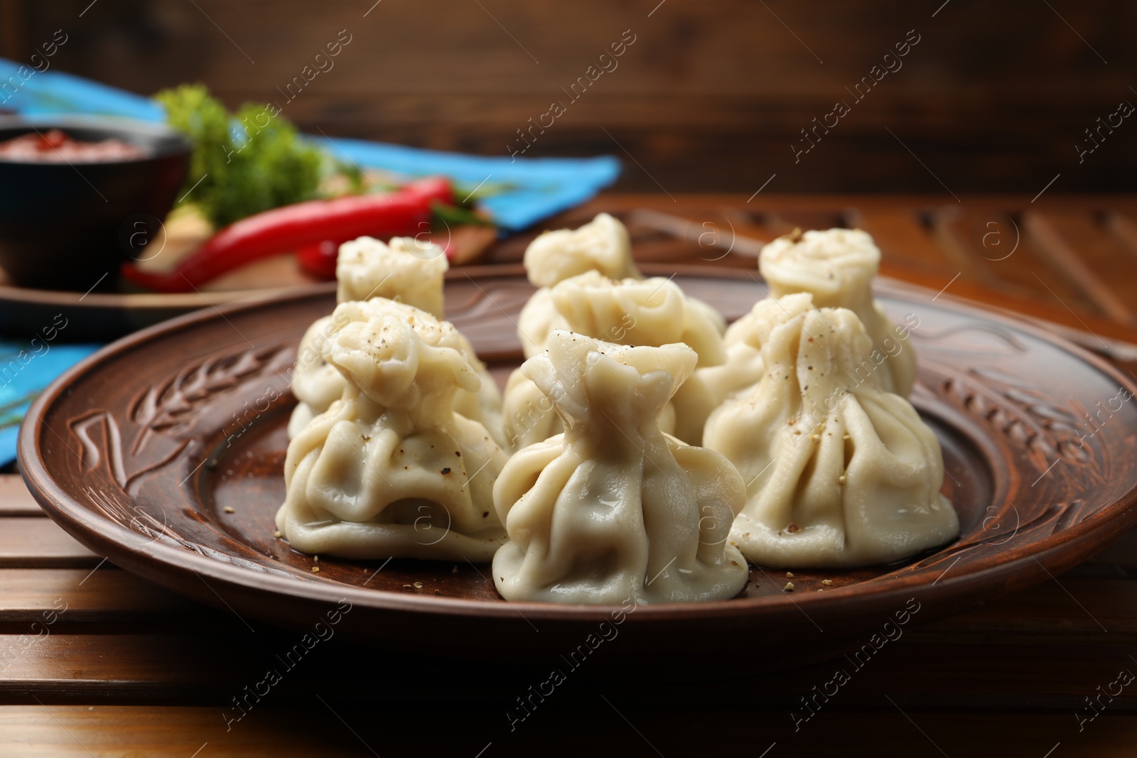 Delicious khinkali served on wooden table, closeup Photo of Delicious khinkali served on wooden table, closeup