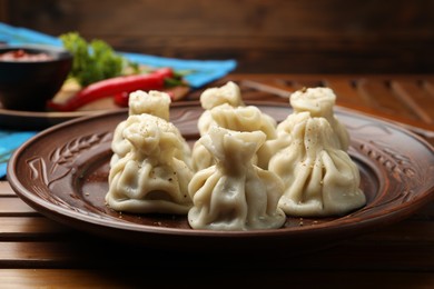 Photo of Delicious khinkali served on wooden table, closeup