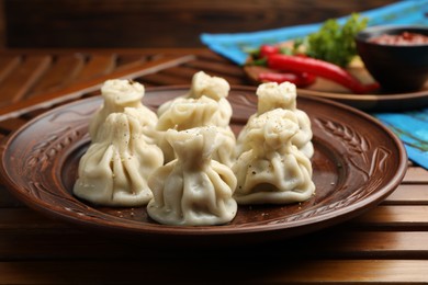 Photo of Delicious khinkali served on wooden table, closeup