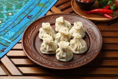 Photo of Delicious khinkali served on wooden table, above view
